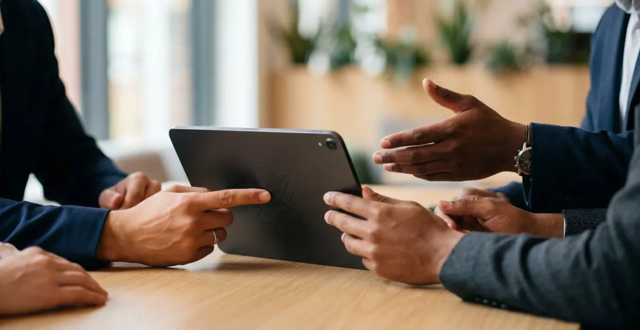 Professional hands collaborating over a secure payment authorization process on a minimalist desk